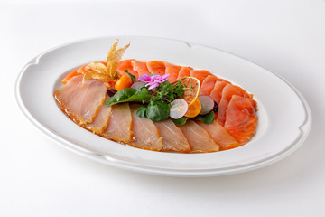 Plate with appetizer of fish and seafood. Sliced salted fish fillet. Smoked salmon, tuna, perch. Banquet festive dishes. Gourmet restaurant menu. White background.