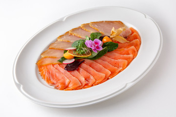 Plate with appetizer of fish and seafood. Sliced salted fish fillet. Smoked salmon, tuna, perch. Banquet festive dishes. Gourmet restaurant menu. White background.