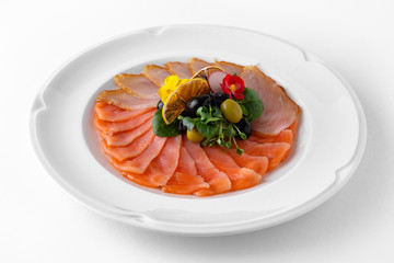 Plate with appetizer of fish and seafood. Sliced salted fish fillet. Smoked salmon, tuna, perch. Banquet festive dishes. Gourmet restaurant menu. White background.