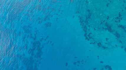 Fototapeta na wymiar Blue tropical clear sea surface with waves and ripples. View from drone.