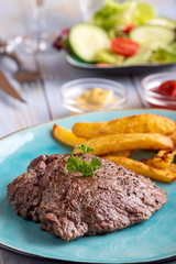 steak on a plate with french fries