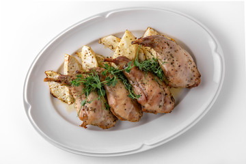 Baked tender juicy rabbit legs with celery. Banquet festive dishes. Gourmet restaurant menu. White background.