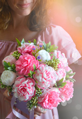 Bouquet of peonies on woman hands. . Mothers day, Womens day, Valentines day, birthday or wedding greeting card. Sun light effect.