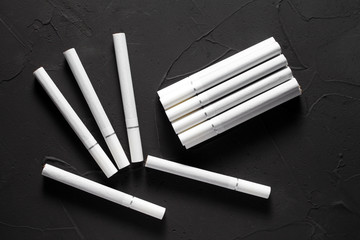 Cigarettes with a white filter on a dark concrete background