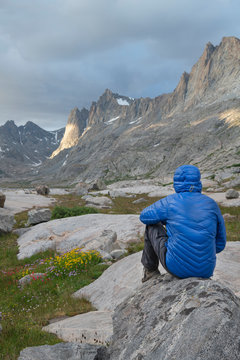 Hiker enjoying the view in Titcomb Basin. Bridger Wilderness. Wind River Range Wyoming; Adult male hiker in blue jacket enjoying the view in Titcomb Basin. Bridger Wilderness. Wind River Range Wyoming. Wyoming. United States