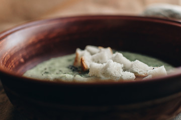 Green cream vegetable soup broccoli, peas, zucchini, spinach with croutons. Delicious vegetarian healthy food.