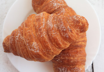 fresh croissants on white plate