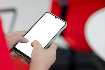 Woman with modern mobile phone in hands touching on a blank screen