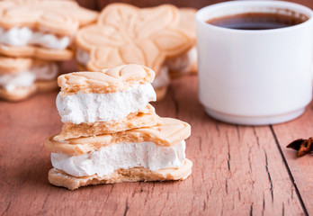 Shortbread cookies with meringue in the form of a flower, on a light wood background.
