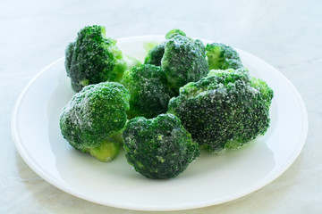 frozen green broccoli on the white plate and white background