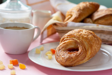 A variety of puff pastry buns with cherries, kiwi, apricot. Rolls, croissants with various fillings. A Cup of coffee with milk, Breakfast. Still-life.