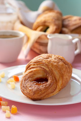 A variety of puff pastry buns with cherries, kiwi, apricot. Rolls, croissants with various fillings. A Cup of coffee with milk, Breakfast. Still-life.