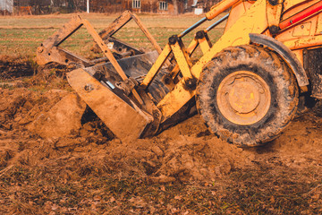 The excavator is digging the ground for the foundation and construction of a new road in the...
