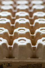 Obraz premium A lot of empty cardboard egg cartons in a row. Bottom of egg trays. Vertical
