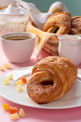 A variety of puff pastry buns with cherries, kiwi, apricot. Rolls, croissants with various fillings. A Cup of coffee with milk, Breakfast. Still-life.