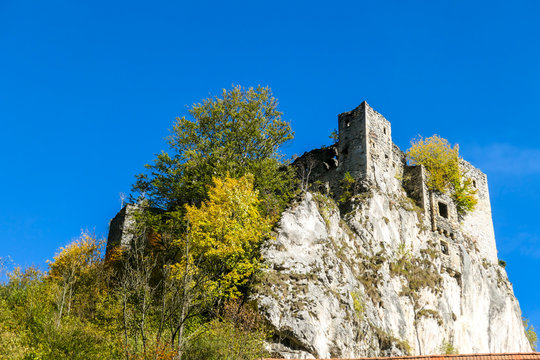 A ruins of Schachenstein castle on top of a hill in Austrian Alps. The ruins are surrounded by colorful trees, sheding leaves for winter. Inaccessible defence construction. Autumn vibes in Alps.