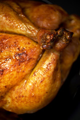 Whole roasted chicken in baking dish. Top view. Copy space. Macro shoot.
