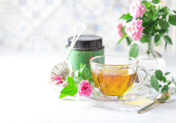 Pink tea buds, a glass cup and vintage strainer.