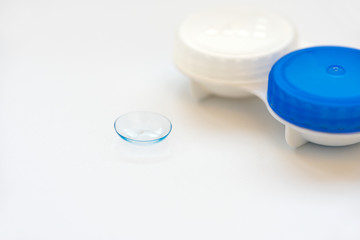 Contact lens and contact lens case on white background. Soft focus. Macro. Opthalmology and health concept