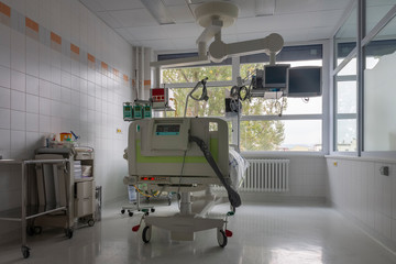 Isolation box in intensive care unit in hospital, bed with monitors, a place where can be  treated patients with pneumonia caused by coronavirus covid 19.