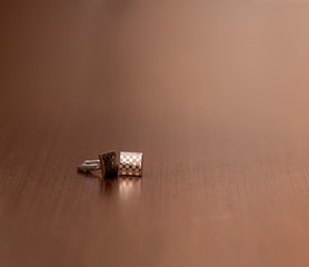 silver cufflinks for shirts on wooden background in all its detail.