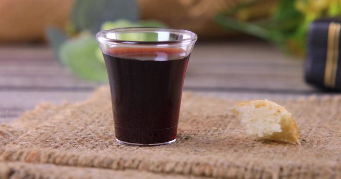 Taking communion concept - the wine and the bread symbols of Jesus Christ blood and body with Holy Bible. Easter Passover and Lord Supper concept. Dolly shot 4k