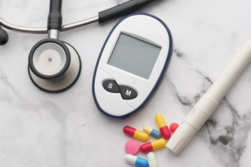 Fototapeta na wymiar blood sugar measurement for diabetes, pills, and stethoscope 