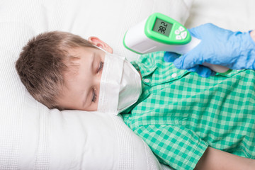 Sleeping boy measure the temperature with a thermometer