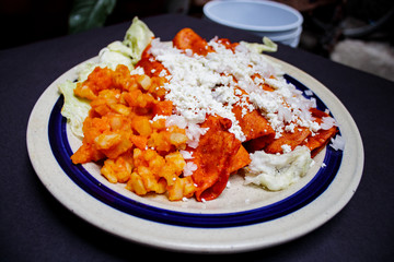 Enchiladas, platillo típico mexicano. Hecho con chiles guajillos y tortillas. Acompañado de cebolla, crema, queso, zanahorias, ppapas y lechuga