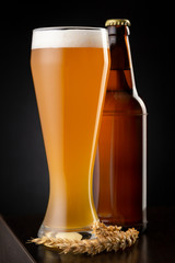 Pint of unfiltered wheat beer and beer bottle