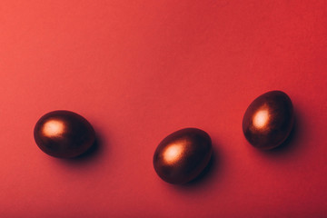 Color easter eggs on a red textured background.