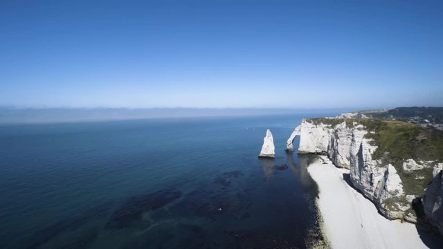 Aerial view of white stunning cliffs and blue endless sea on a summer sunny day. Action. Amazing seascape with rocks on blue sky background.