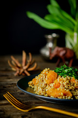 Bulgur with pumpkin on a wooden table. Vegetarian recipes from Indian cuisine.