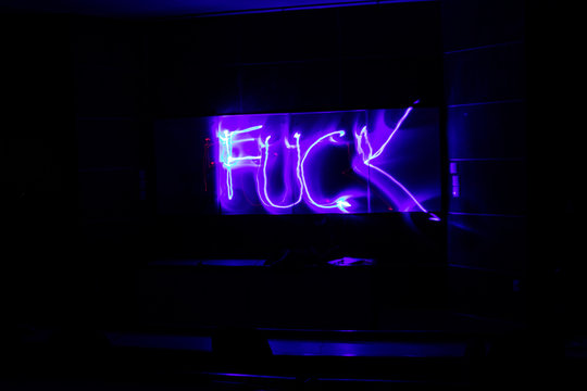 Pintando figuras con luz sobre un fondo blanco en un cuarto oscuro