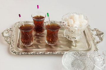 Traditional Turkish Tea in crystal glasses on vintage silver tray with white cube sugar.Festival concept.