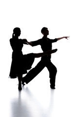 Fototapeta na wymiar silhouettes of elegant couple of ballroom dancers dancing on white