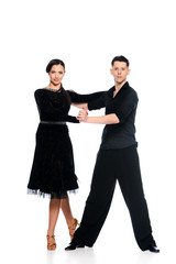 elegant young couple of ballroom dancers in black dress and suit dancing isolated on white