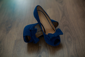 women's blue high heeled shoes with space for text. elegant shoes for evening dress bright blue female sandals. fashion bridal summer shoes with bow on  wooden background close up. wedding accessories