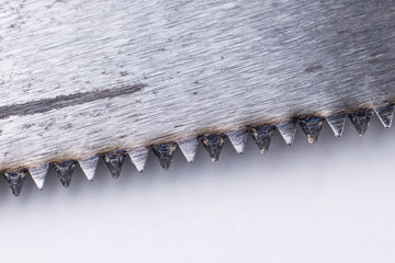 Fragment of a saw blade with scuffs. Particles of wood on metal teeth