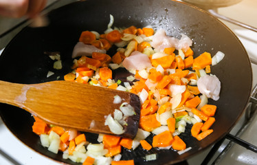 Frying carrots and onion in the pan. Homemade food. Healthy vegetables.