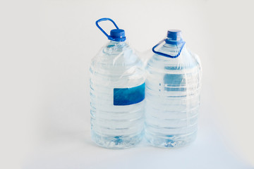 Close-up shot of plastic bottles of water in transparent wrap on white surface