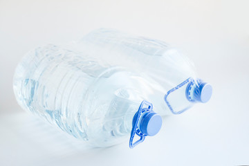 Close-up shot of plastic bottles of water in transparent wrap on white surface