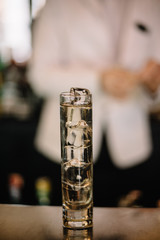 Gin and tonic cocktail in a highball glass decorated with a bunch of dried flowers. Light background. Smooth image with shallow depth of field.