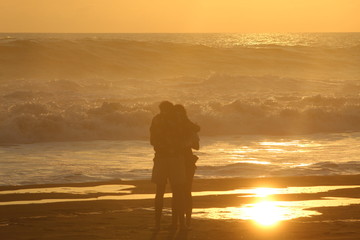 Pareja viendo el atardecer en la playa