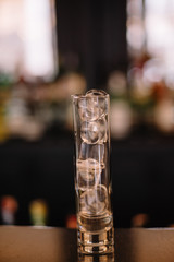 Gin and tonic cocktail in a highball glass decorated with a bunch of dried flowers. Dark background. Smooth image with shallow depth of field.