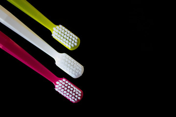 Bright toothbrushes close-up on a black background.