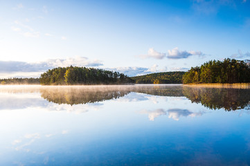 Reflections and mist at still lake, Sweden