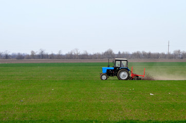 Tractor cultivates land on  the field ,Ukraine.
