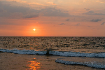 Sunset ocean beach landscape view with waves and red sky, Sri Lanka