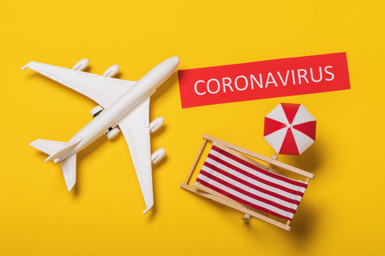 A toy plane, a tag with an inscription and beach accessories on a yellow background. Coronavirus outbreak concept COVID-19
